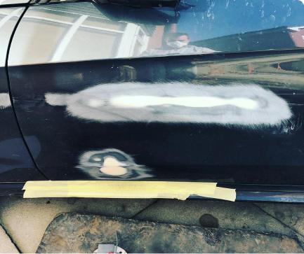 repaired dent and scratch on side of a black car door